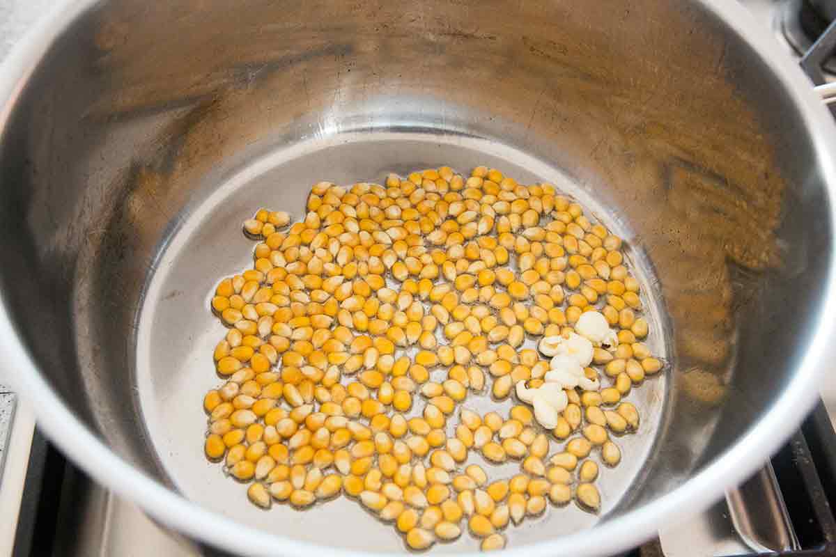 when the popcorn kernels pop, add the rest of the kernels in an even layer