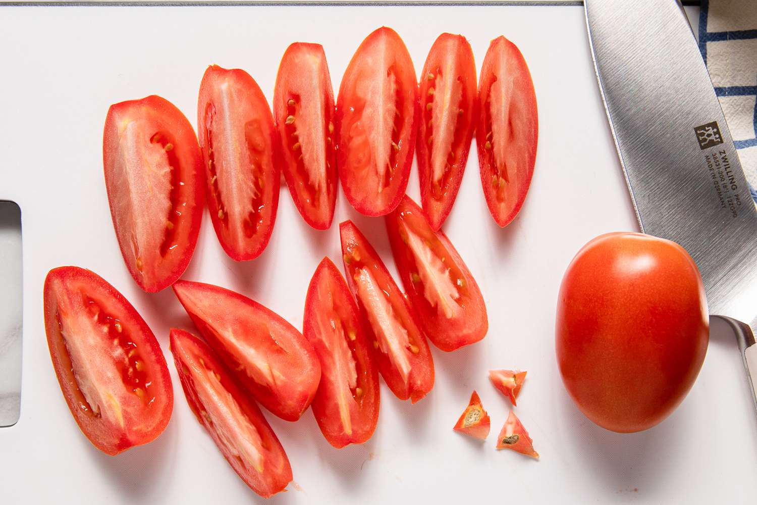 Wedges of cut fresh tomato on a cutting board