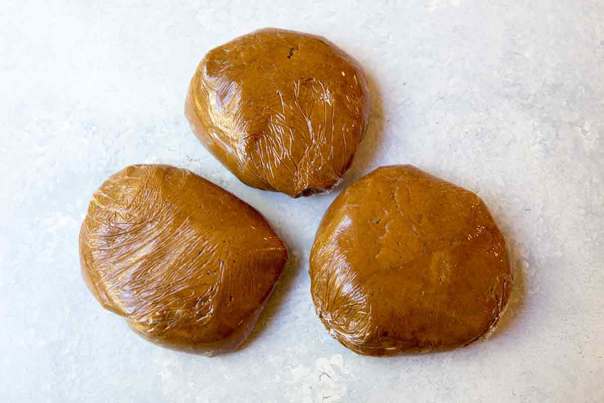Balled Gingerbread Man Cookie Dough in Plastic Wrap