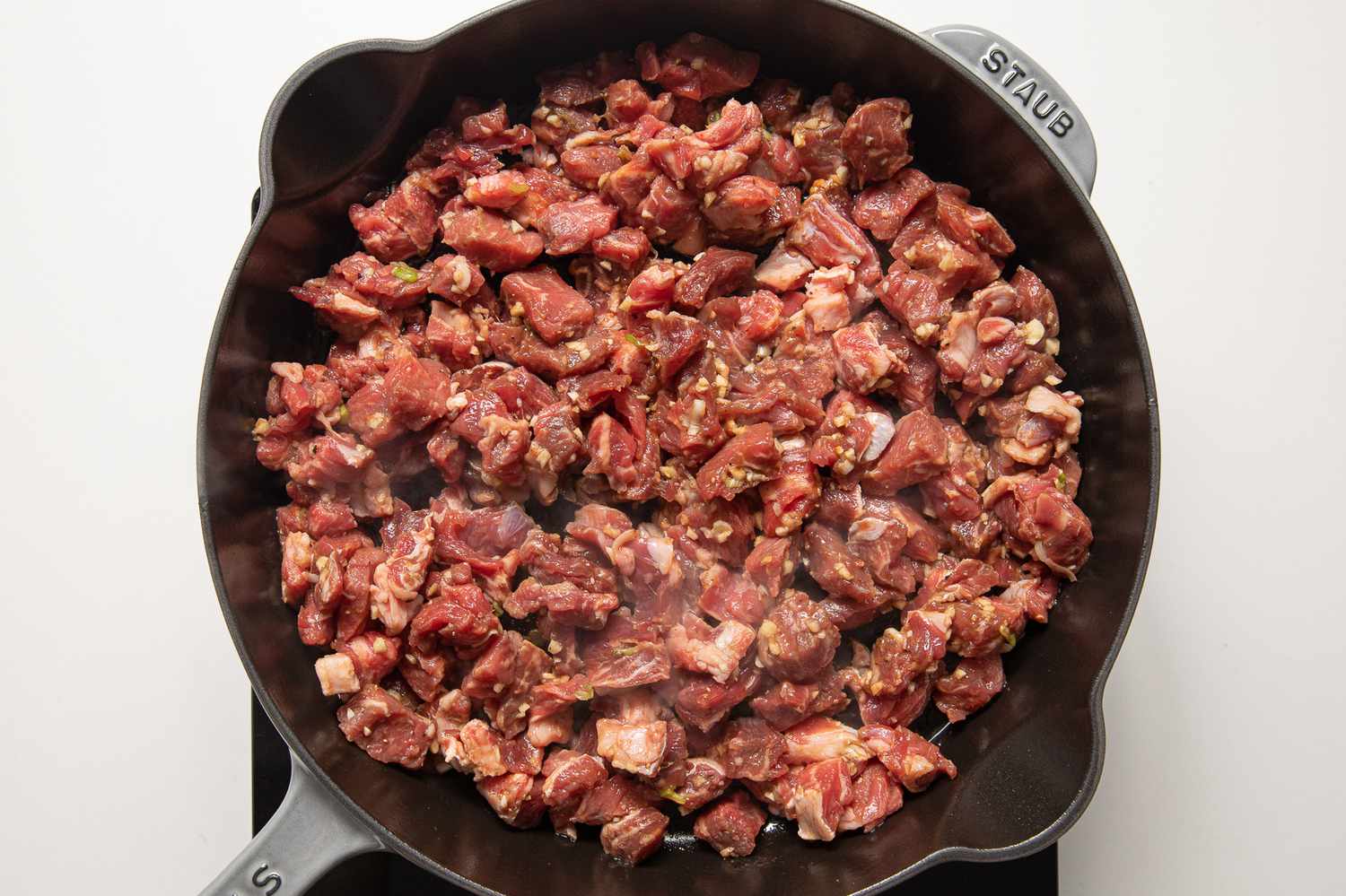 Marinated Cubed Beef Cooking in a Cast Iron Skillet for Shaking Beef Recipe