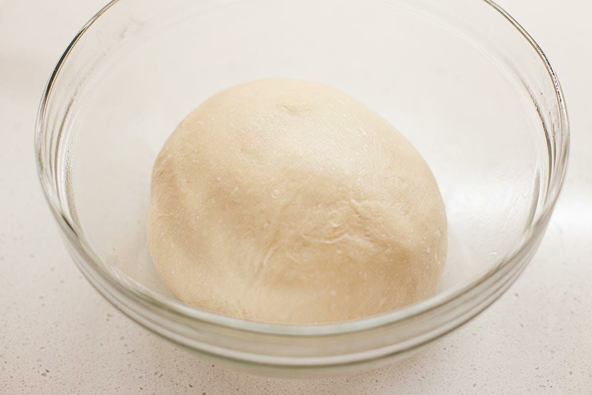 A glass bowl with Utah's Famous Lion House Roll dough inside.