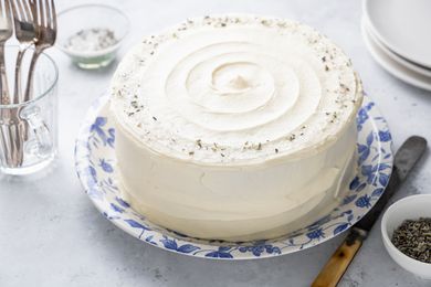 Lemon Lavender Cake Surrounded by Forks, a Small Bowl of Lavender, and Plates