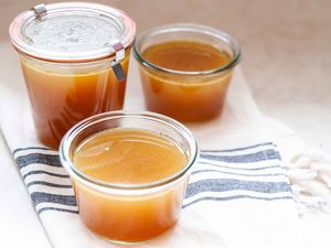 Turkey stock with leftover bones in glass containers.