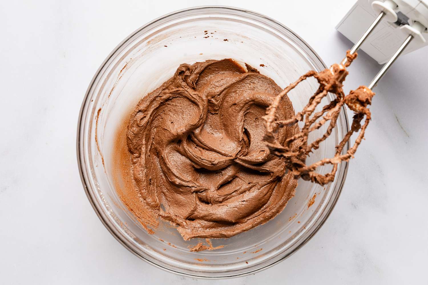 milk and vanilla extract added to bowl of frosting for devil's food cake recipe