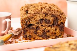 On a Platter, Chocolate Chip Banana Bread Cake Showcasing a Cross Section Cut, a Knife, and a Tea Cup