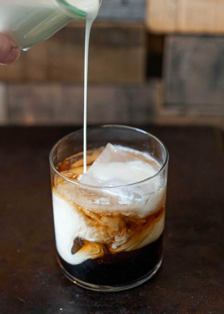 Pour heavy cream into the vodka and kahlua for a white russian cocktail