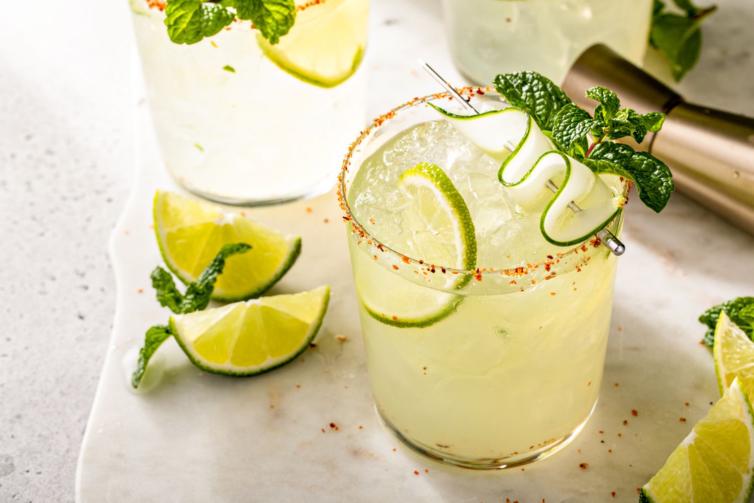 Cucumber margarita with lime and spicy rim, garnished with sliced cucumber and mint