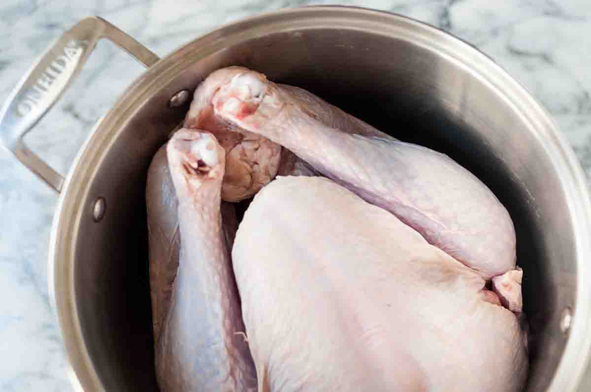 An uncooked turkey resting in a pot