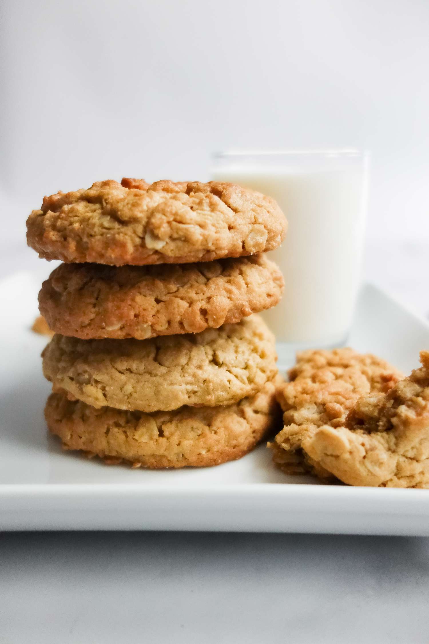 Stack of Chewy Peanut Butter Oatmeal Cookies on a Plate with a Glass of Milk