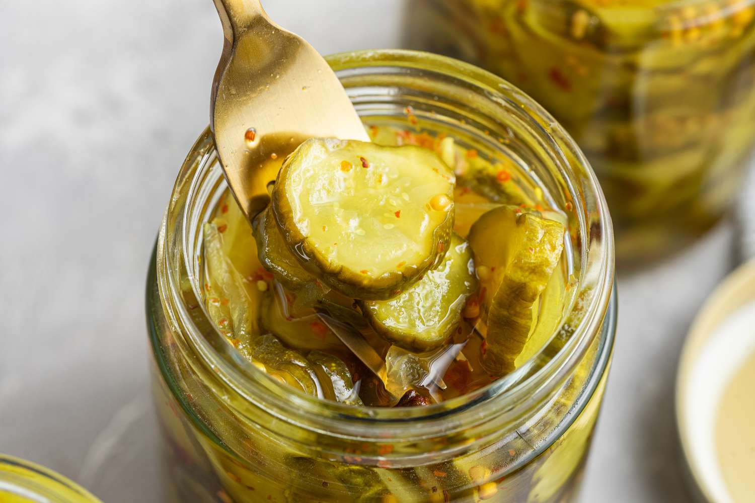 Overhead of Bread and Butter Pickles Picked up from a Jar Using a Fork