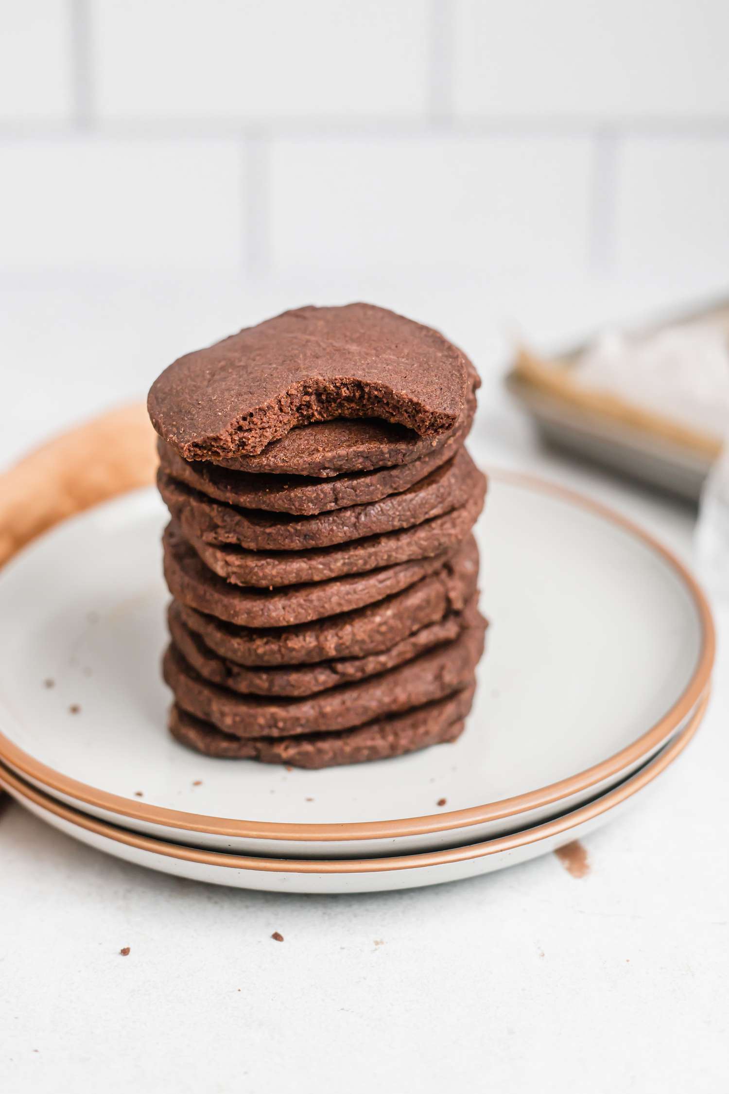 A stack of easy chocolate shortbread with a bite taken out of the top one.