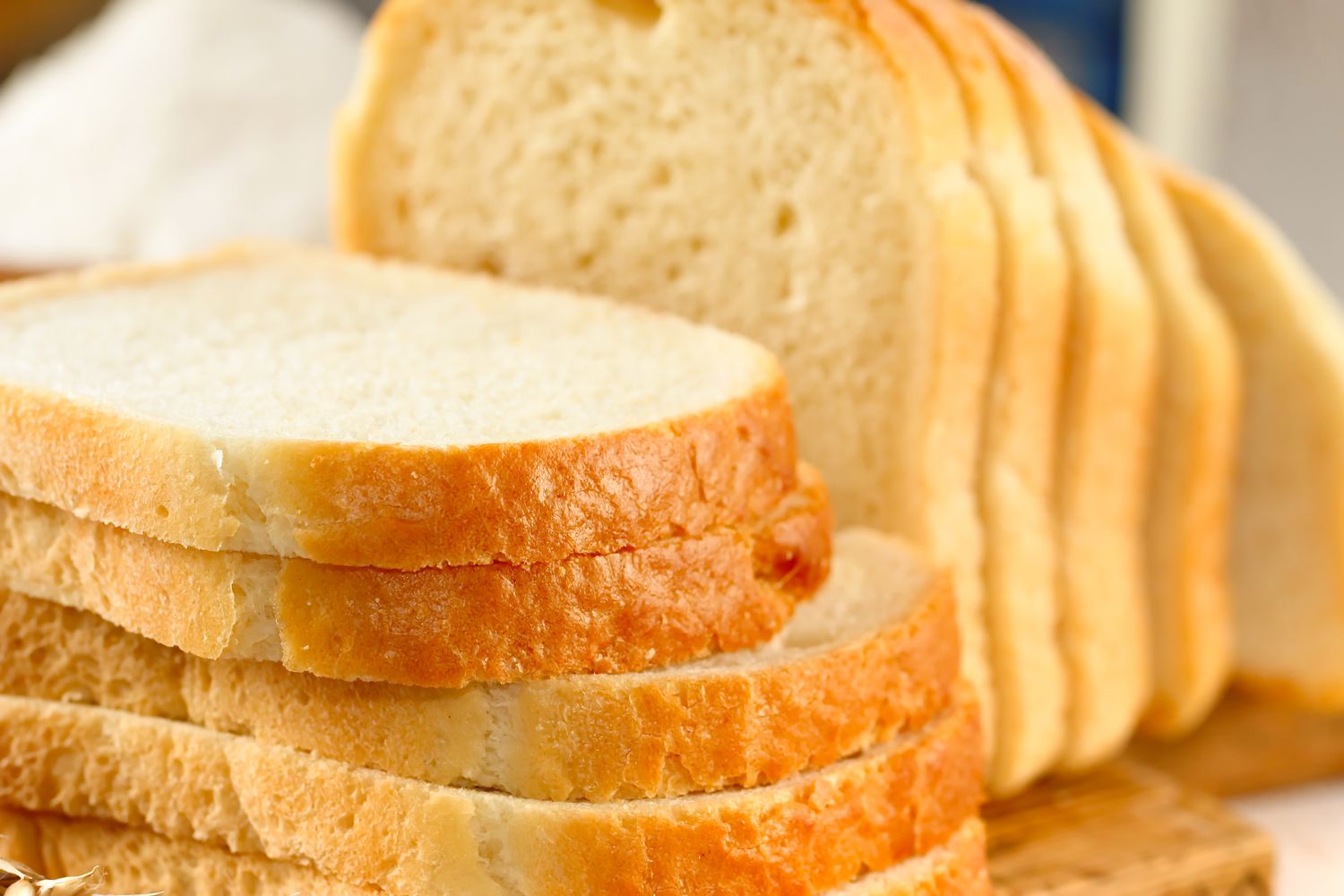 Closeup view of white bread slices on a wooden cutting board