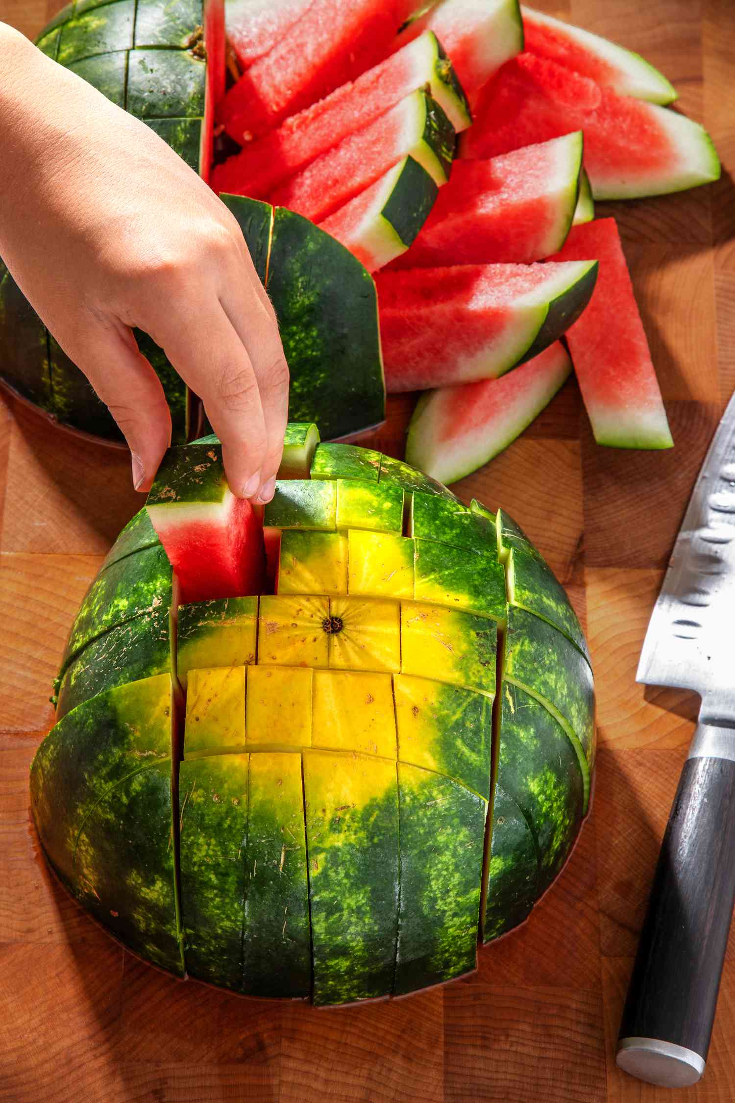 Hand picking up watermelon stick