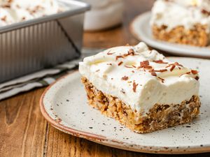 Slice of ritz torte on a plate, and in the background, a baking pan with more and a plate with another slice