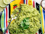 Microwave Arroz Verde on a Plate with a Fork and Surrounded by Lime Wheels, a Bowl of Course Salt, and a Table Napkin