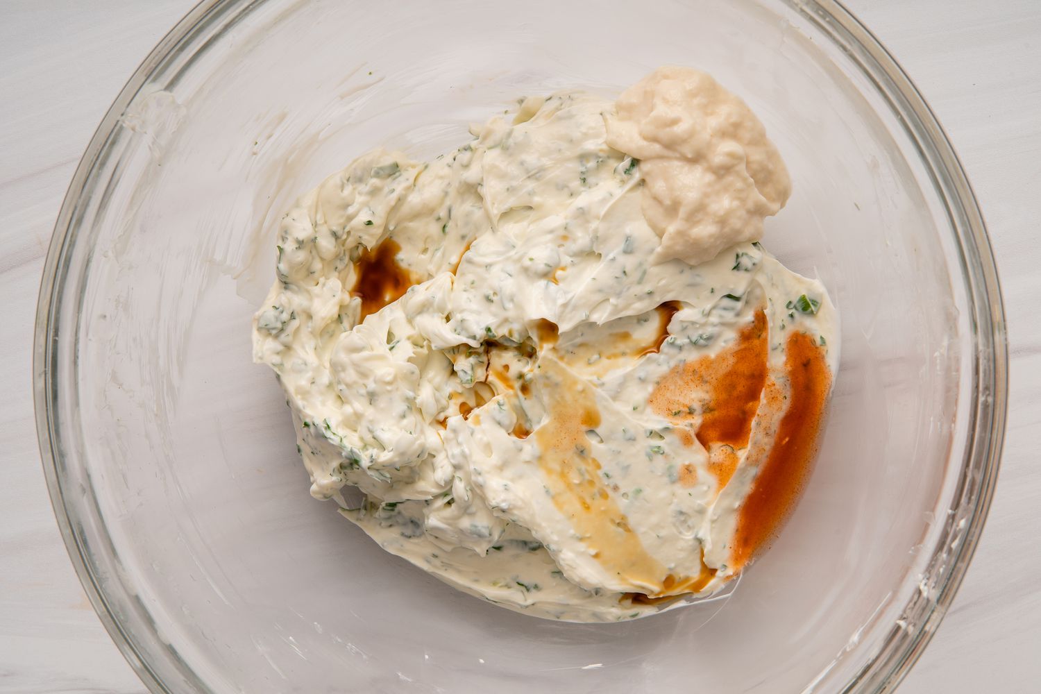 How to make crab dip by mixing ingredients in a glass bowl.
