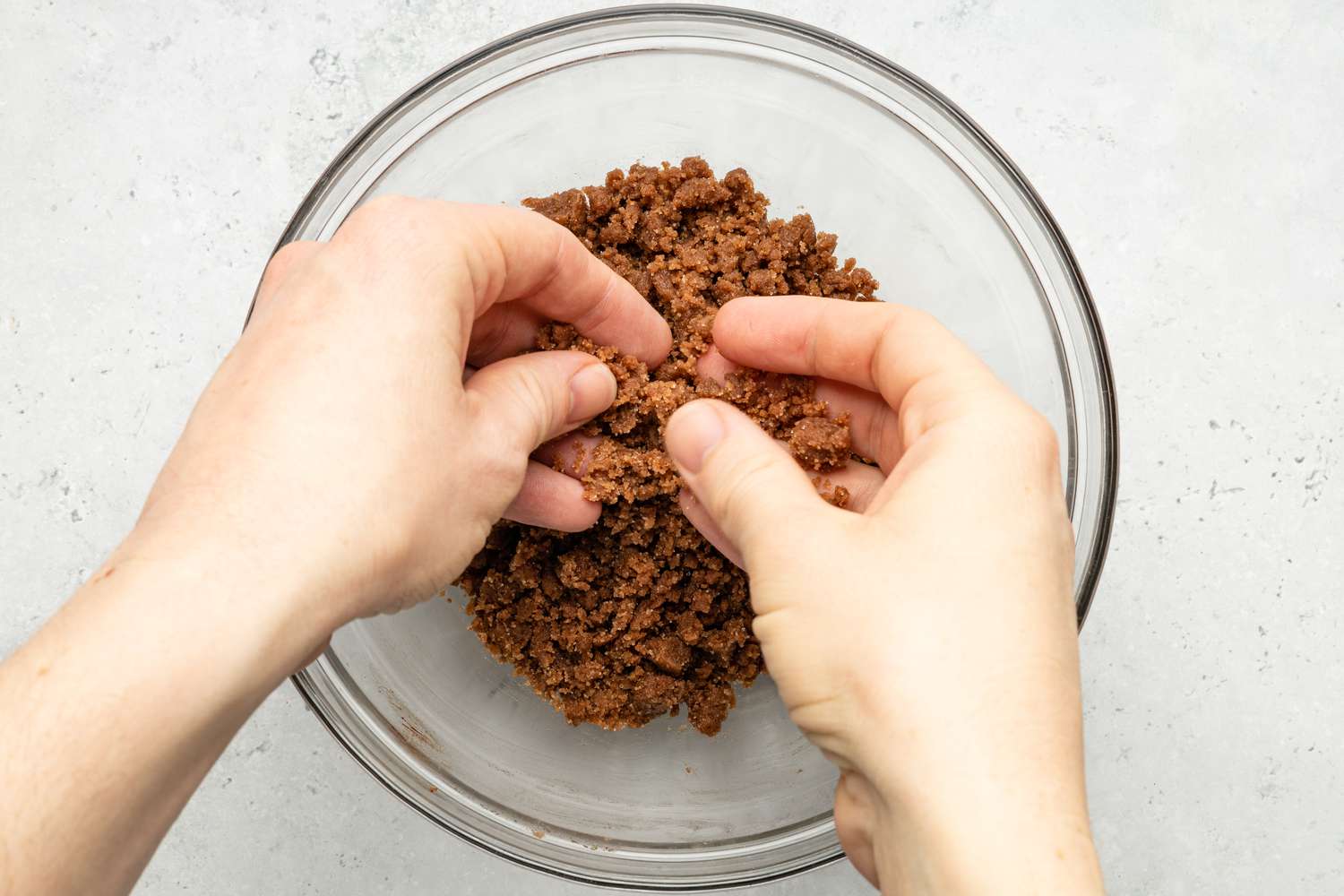 Hands Breaking Chocolate Streusel Into Small Marble Sized Pieces for Chocolate Chip Banana Bread Coffee Cake Recipe