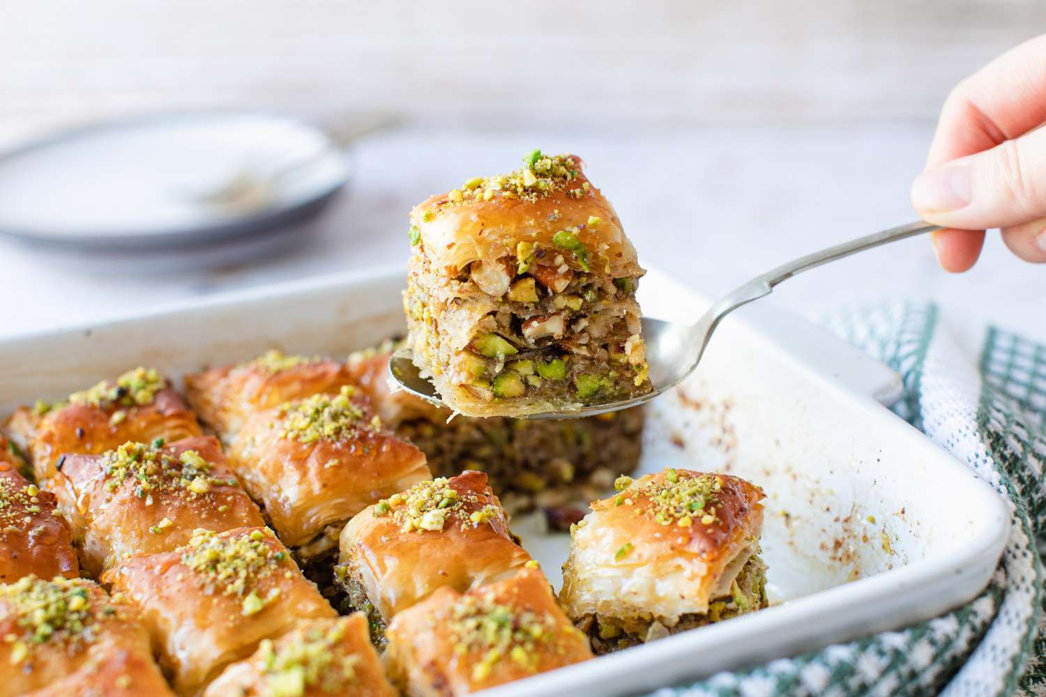 Slice of Baklava Raised from Casserole Dish (with More Baklava) Using a Spoon 