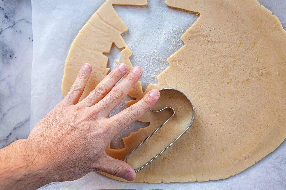 Pressing cookie cutter into rolled out dough to show how to make Sugar Cookies.