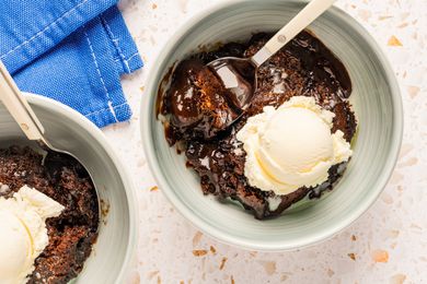 Two bowls with a serving each of southern chocolate cobbler, and topped with a scoop of vanilla ice cream