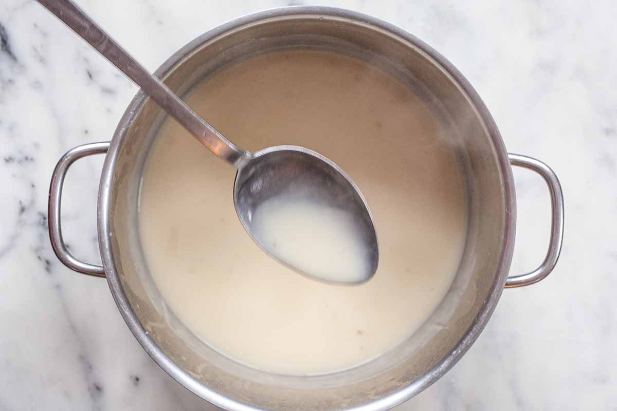 How to Make Shepherd’s Pie Vegetarian -- sauce pan with cream sauce and a spoon