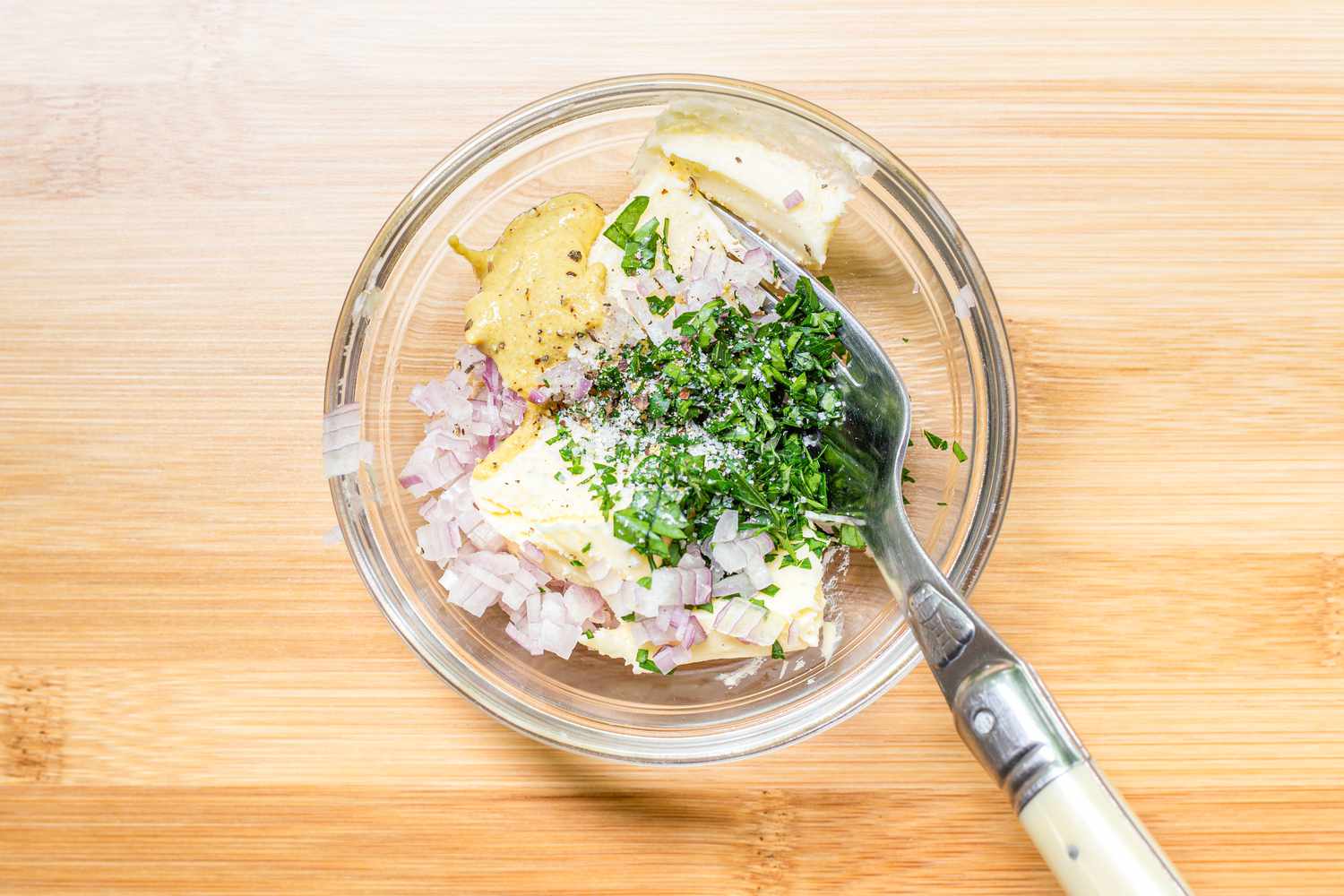 Bowl with Minced Shallots, Mustard, Butter, and Herbs for Hot Ham and Cheese Sandwiches