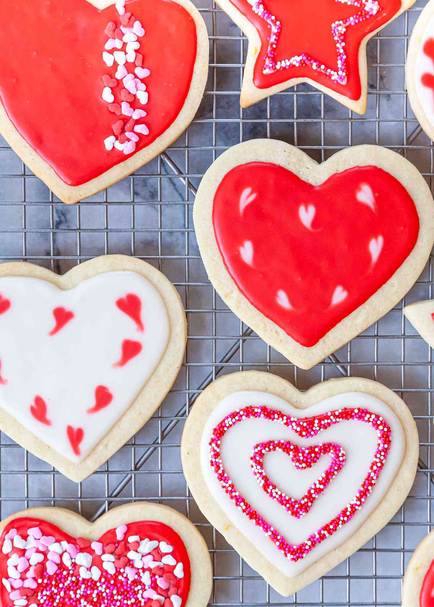 Easy Royal Icing Recipe piped into patterns on heart sugar cookies.