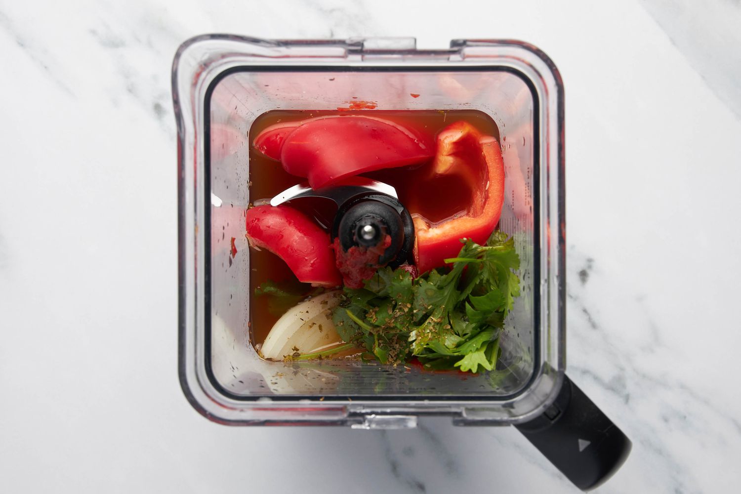 Cilantro, bell pepper, onions, and wet ingredients for the sauce in a blender for carne picada recipe