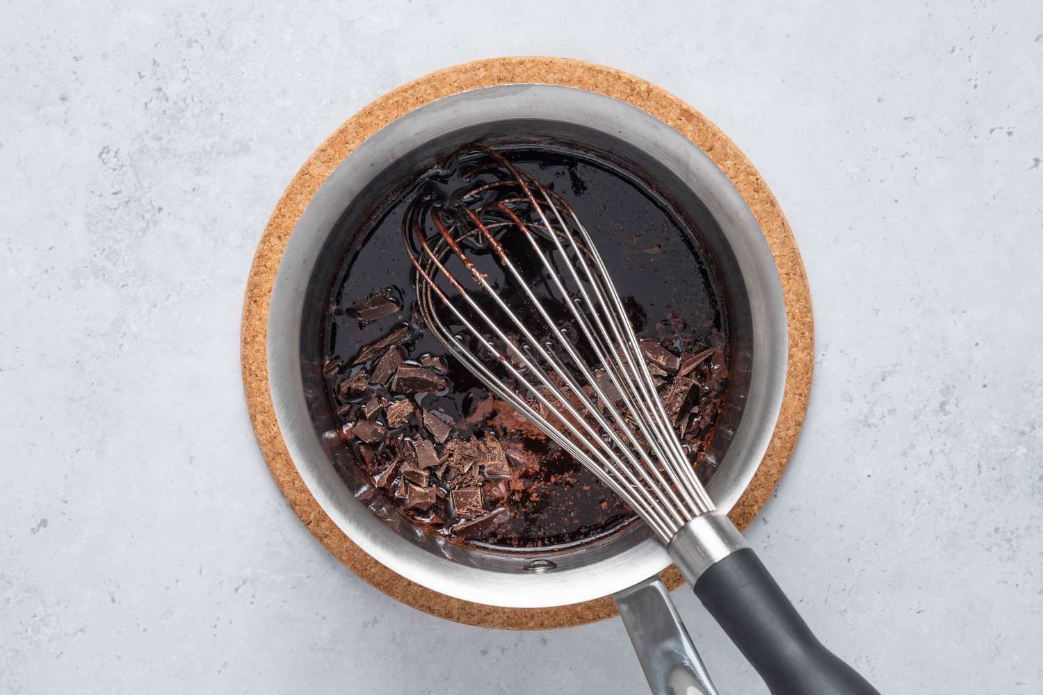 Chocolate pieces added to pot with a whisk for Cosmic Brownie recipe