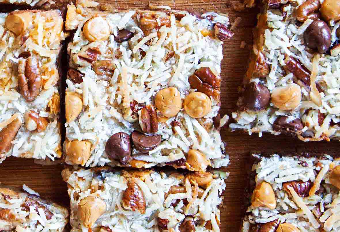 Overhead shot of sliced 7-layer magic bars on a wood surface