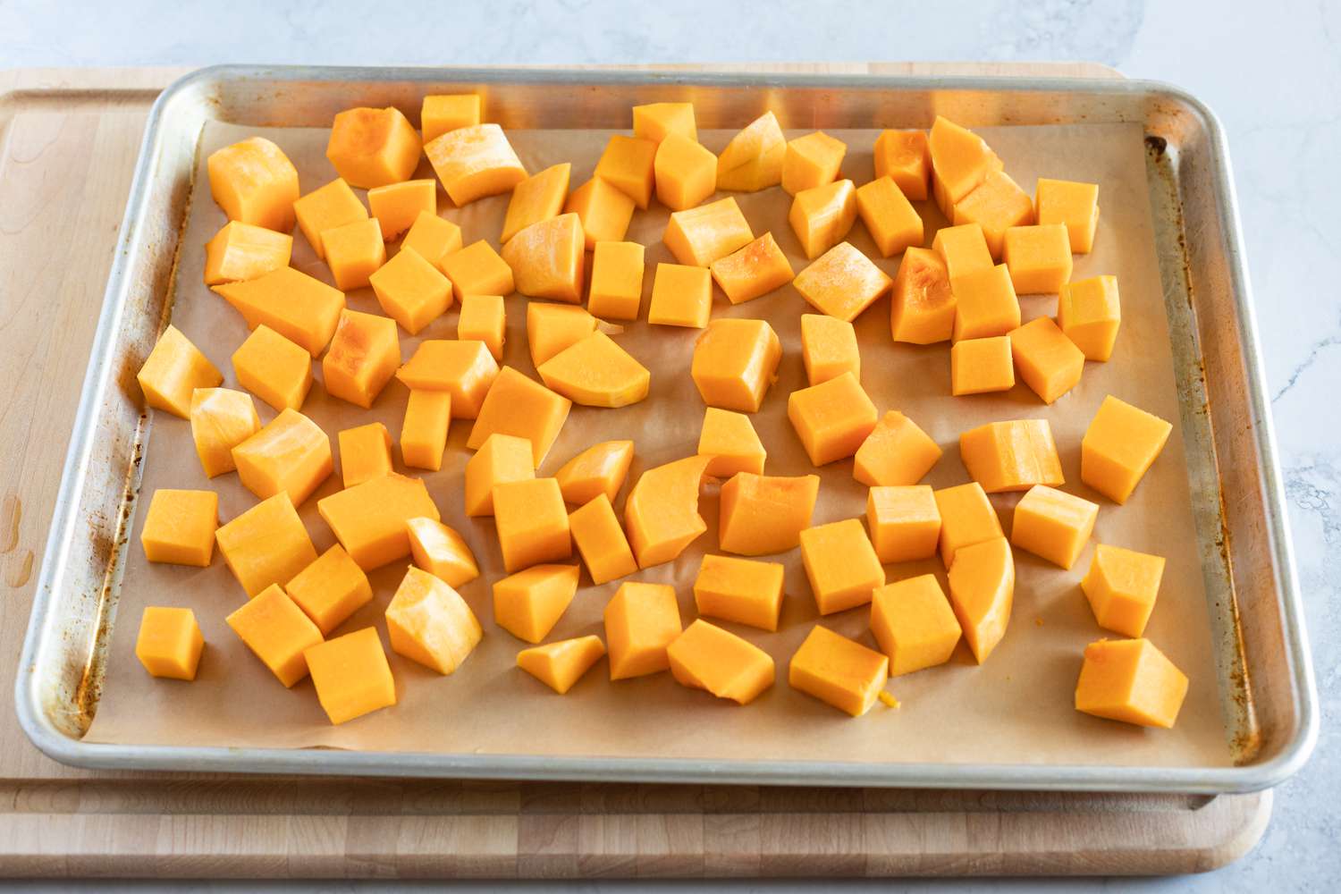 Cubed butternut squash on a sheet pan