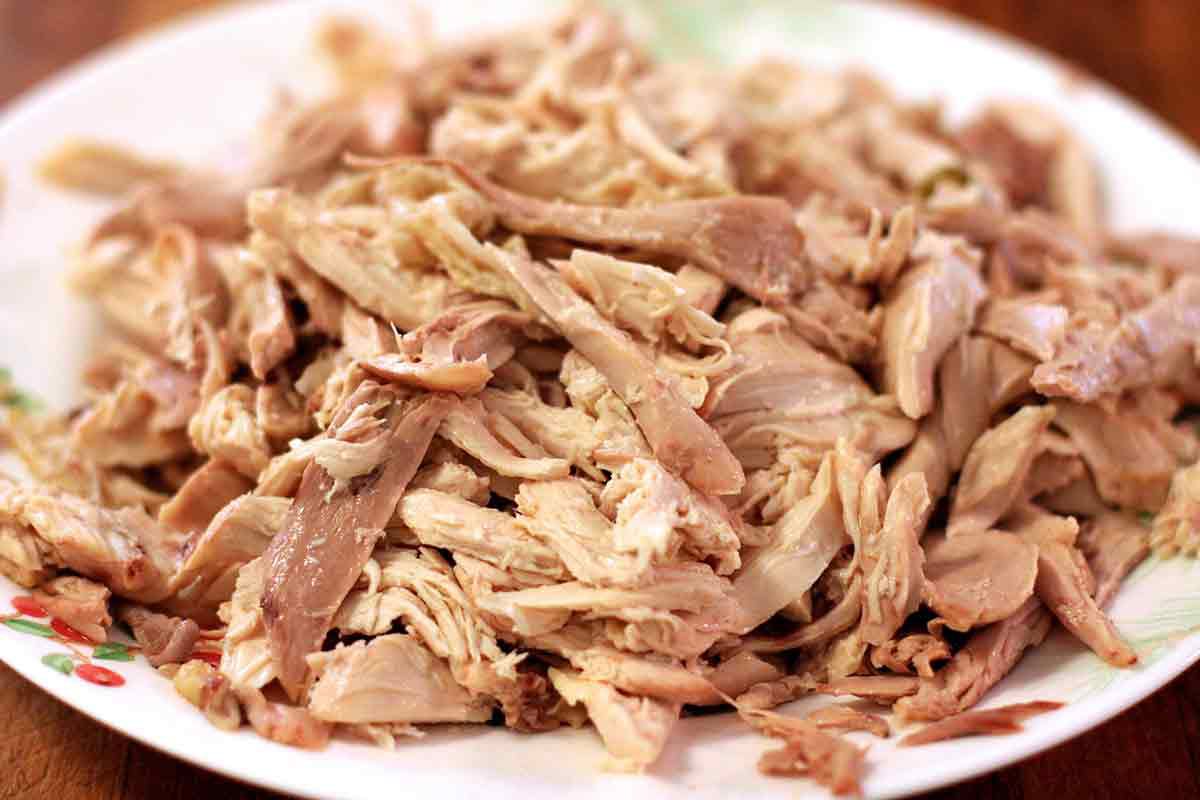 Shredded chicken on a plate to make a homemade chicken pot pie.