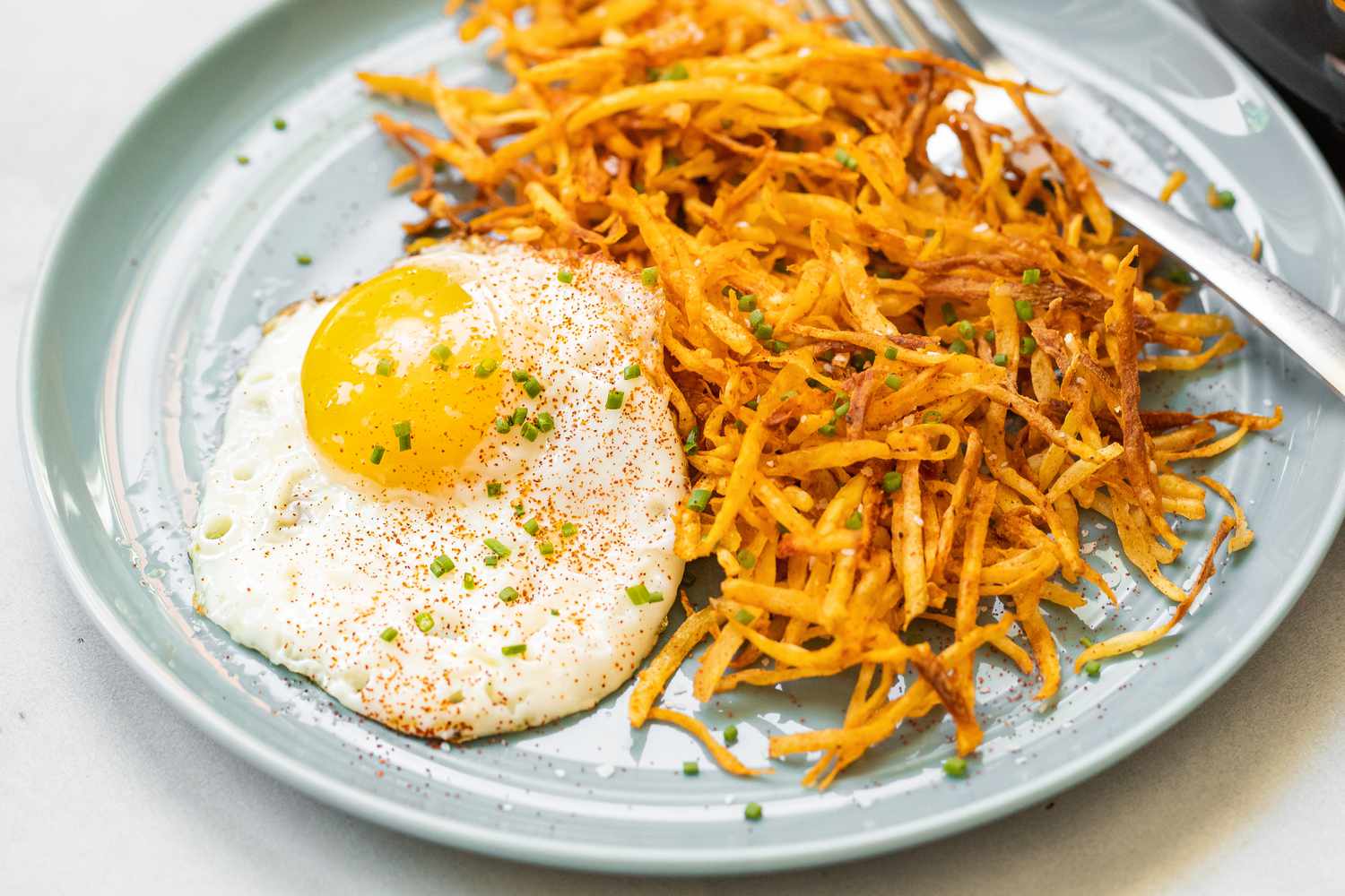 Air Fryer Hash Browns on a Plate with a Sunny Side Egg
