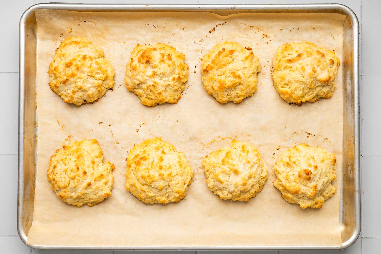 Baked drop biscuits on a parchment paper-lined baking tray