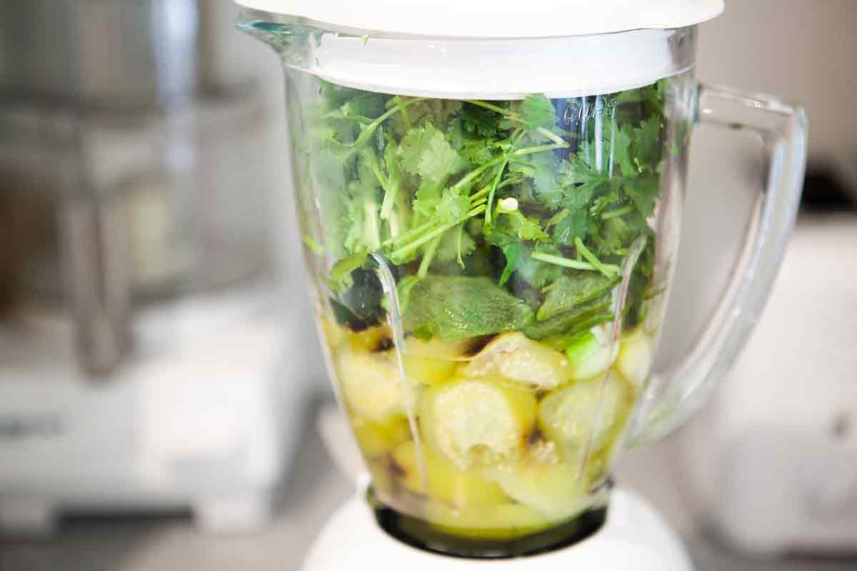 Tomatillos and salsa ingredients in a blender