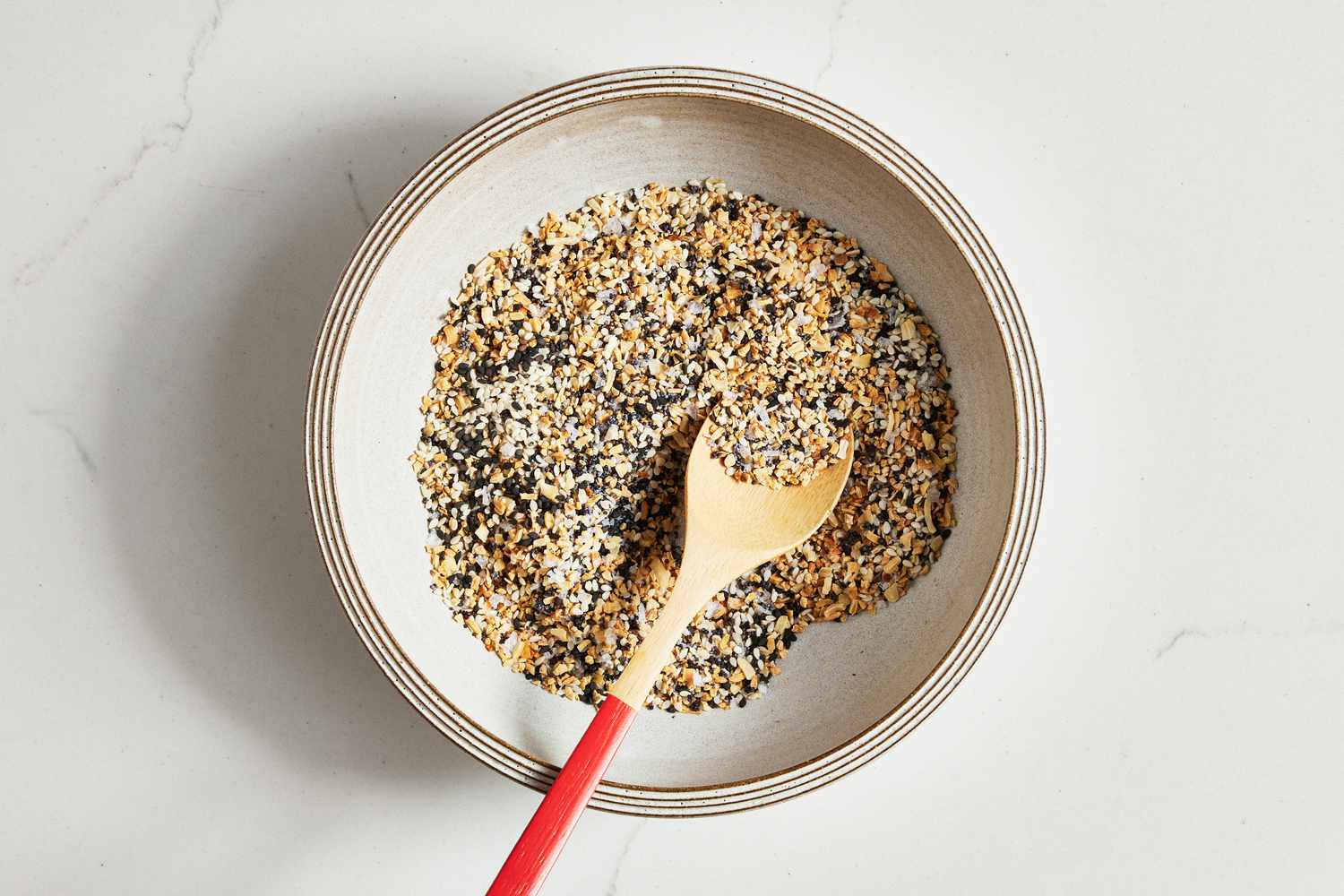 Everything Bagel Seasoning Mixed Together Using a Wooden Spoon