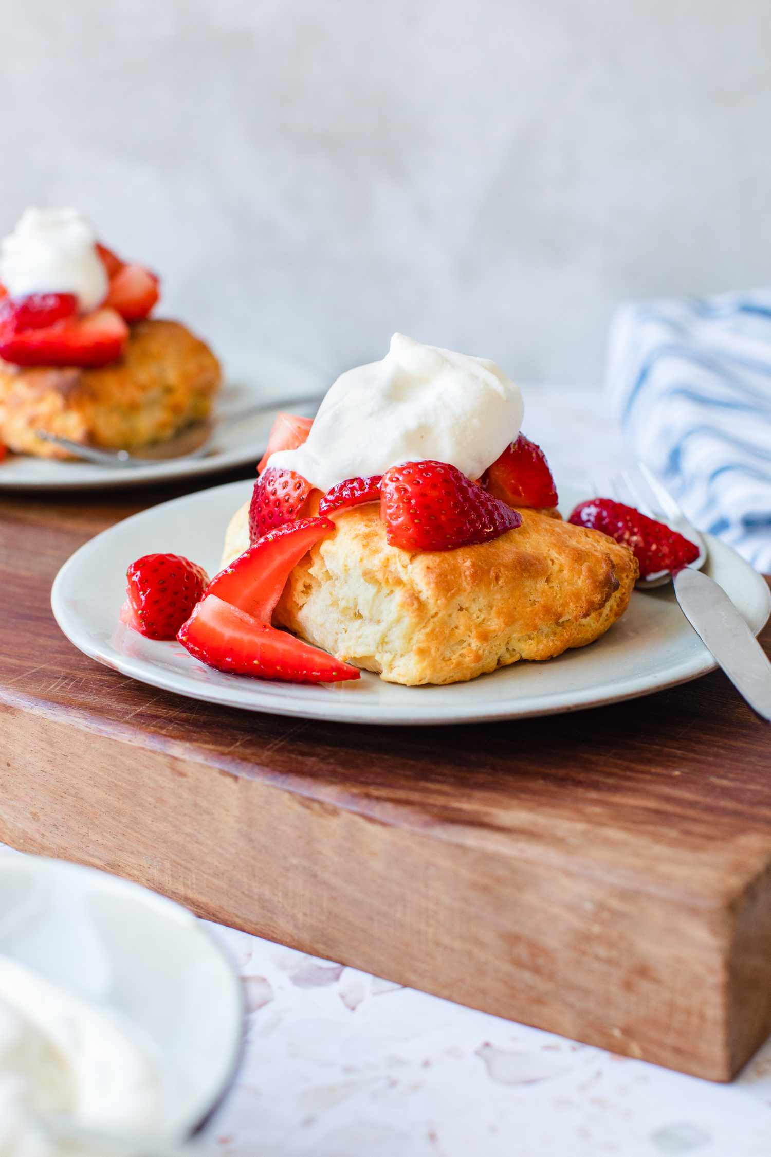 Two Plates of Easy Strawberry Shortcake with a Fork Set on a Wooden Kitchen Block