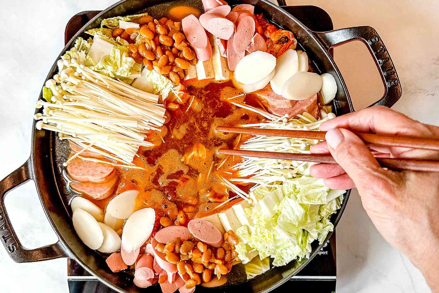 Chopstick stirring the sauce (in the middle of the pot) with the chicken broth. . The other ingredients are not mixed in.