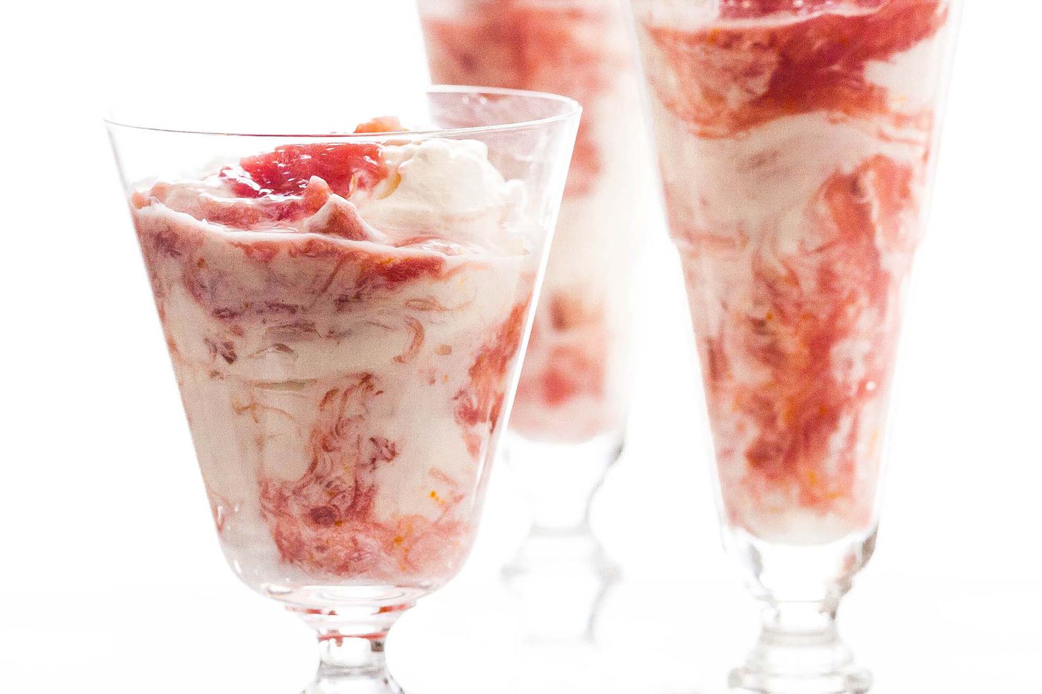 A side shot of a few glasses with rhubarb fool in them, ready to eat