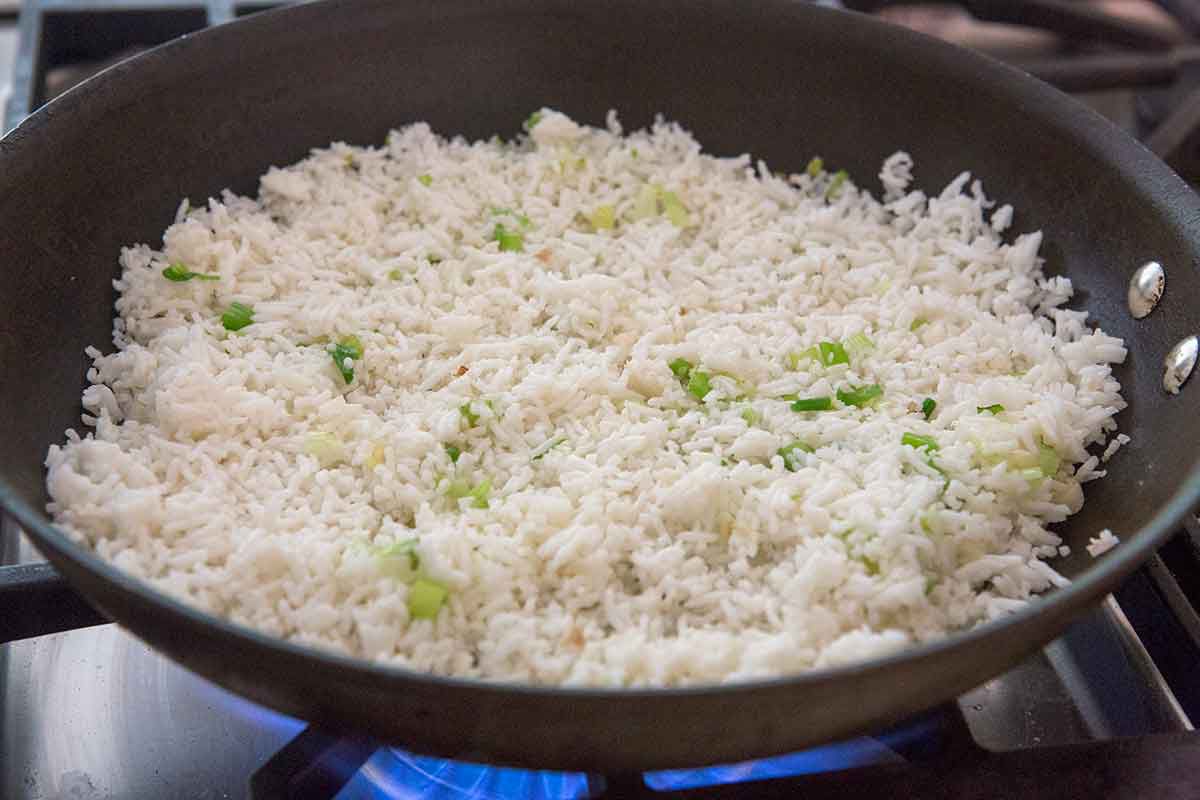 Rice and green onions cooking on a pan