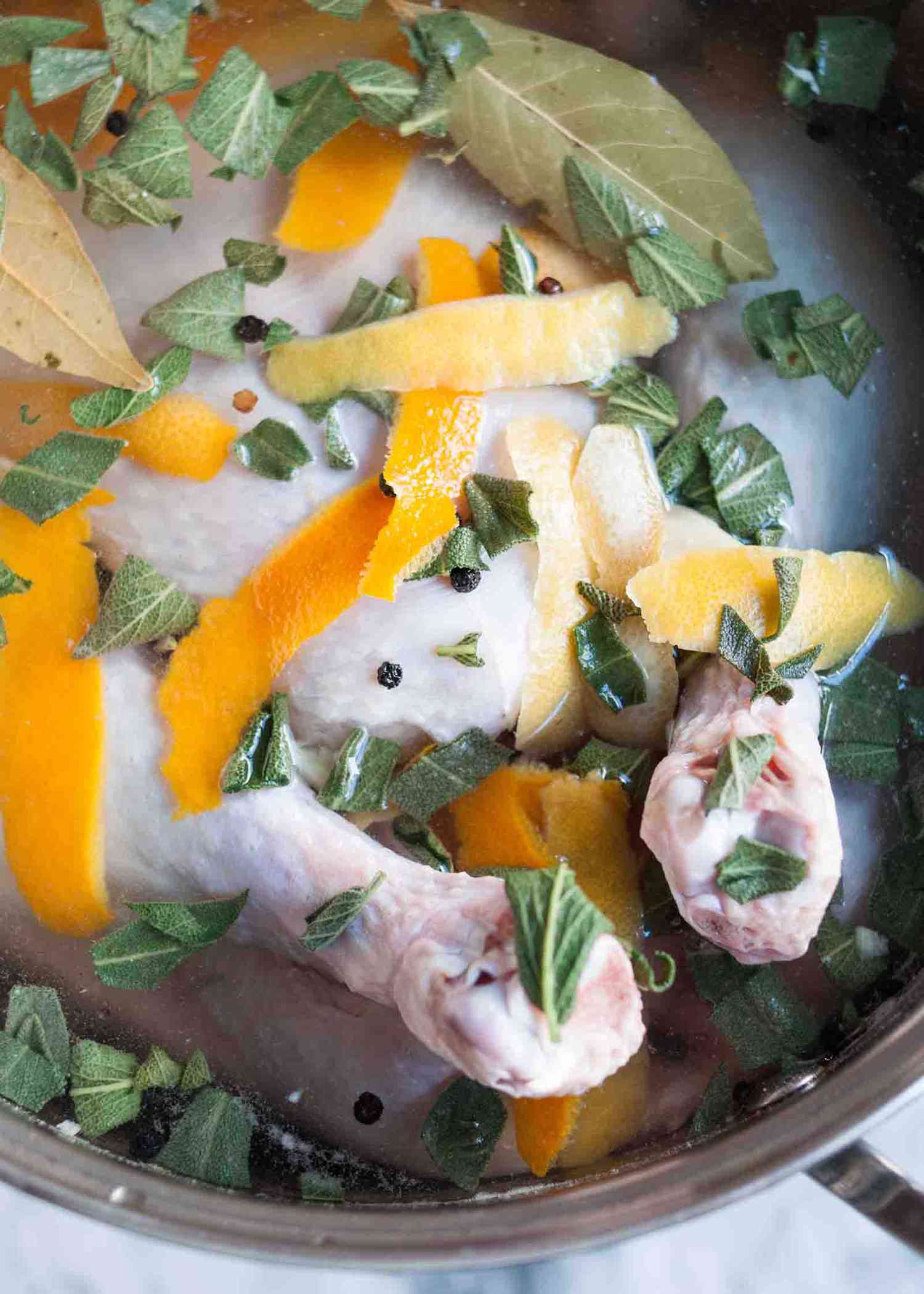 A turkey in a brine with herbs and orange peels