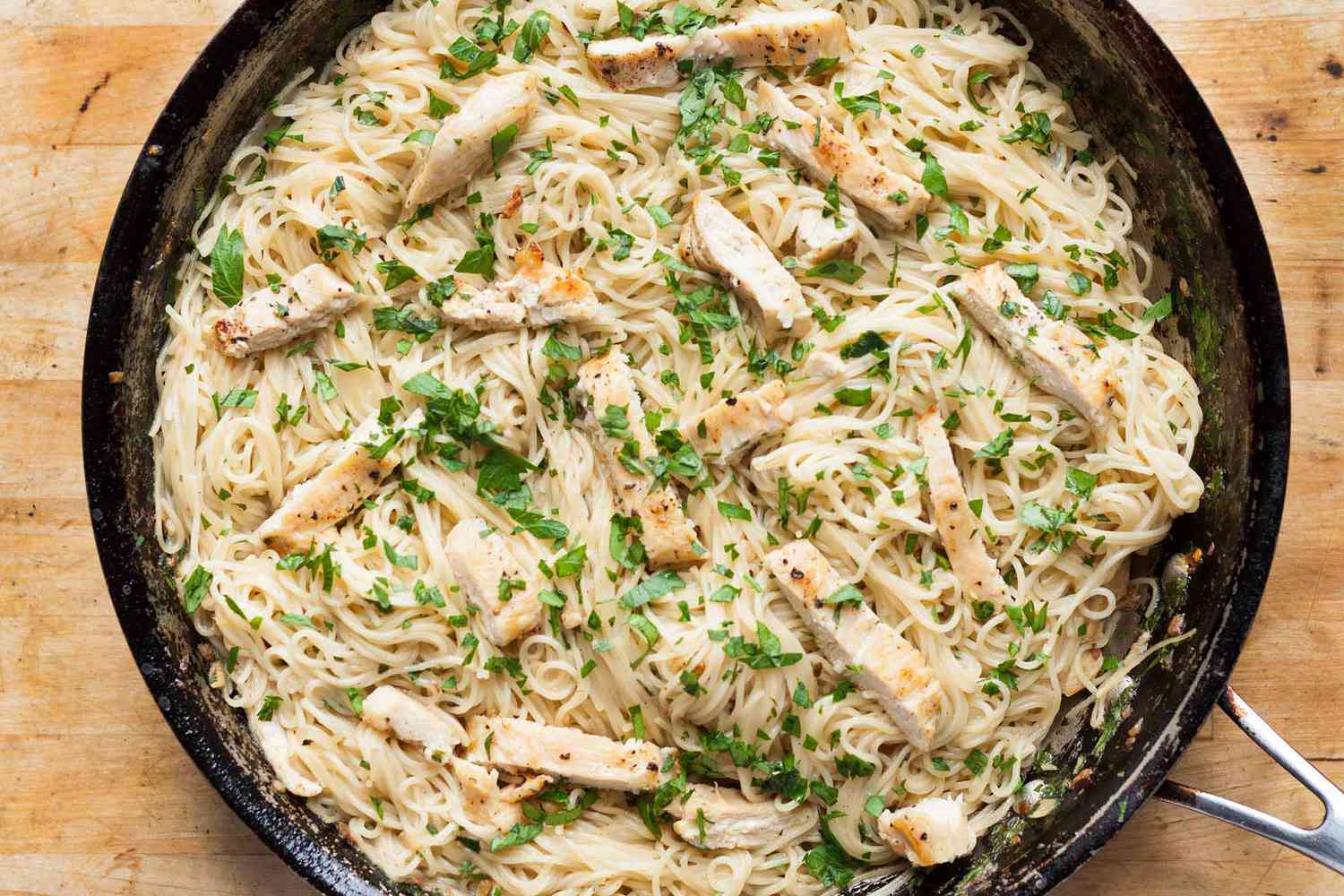 chicken scampi over pasta in a skillet