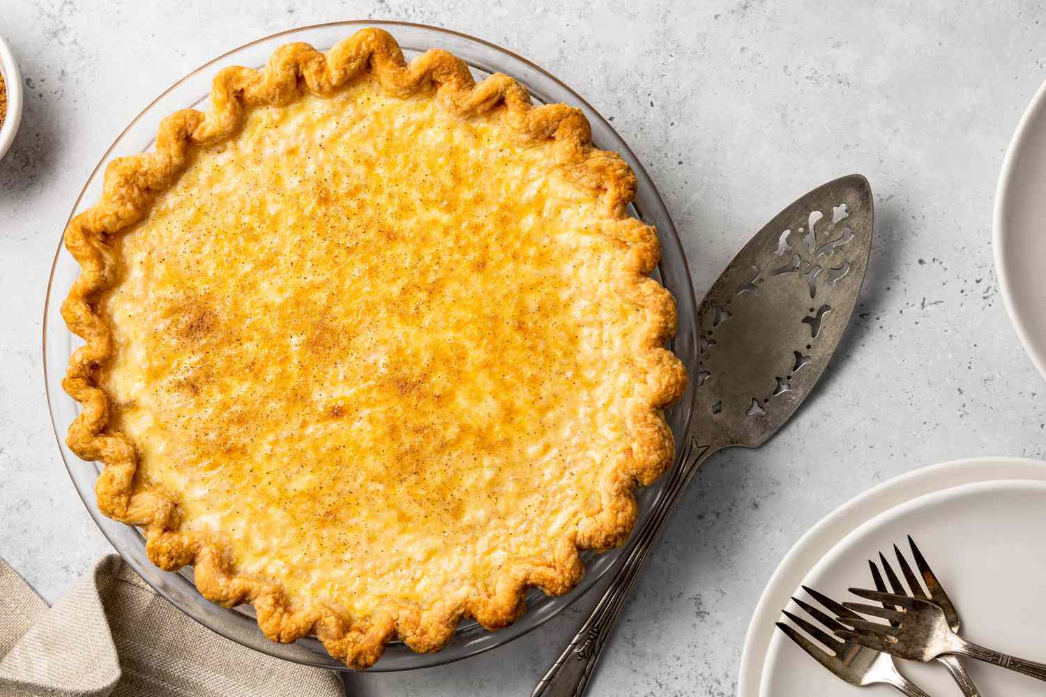 Egg Custard Pie Next to a Pie Server and Plates with Forks 