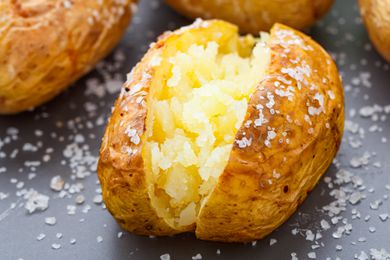 Closeup side view of a baked potato sprinkled with coarse salt