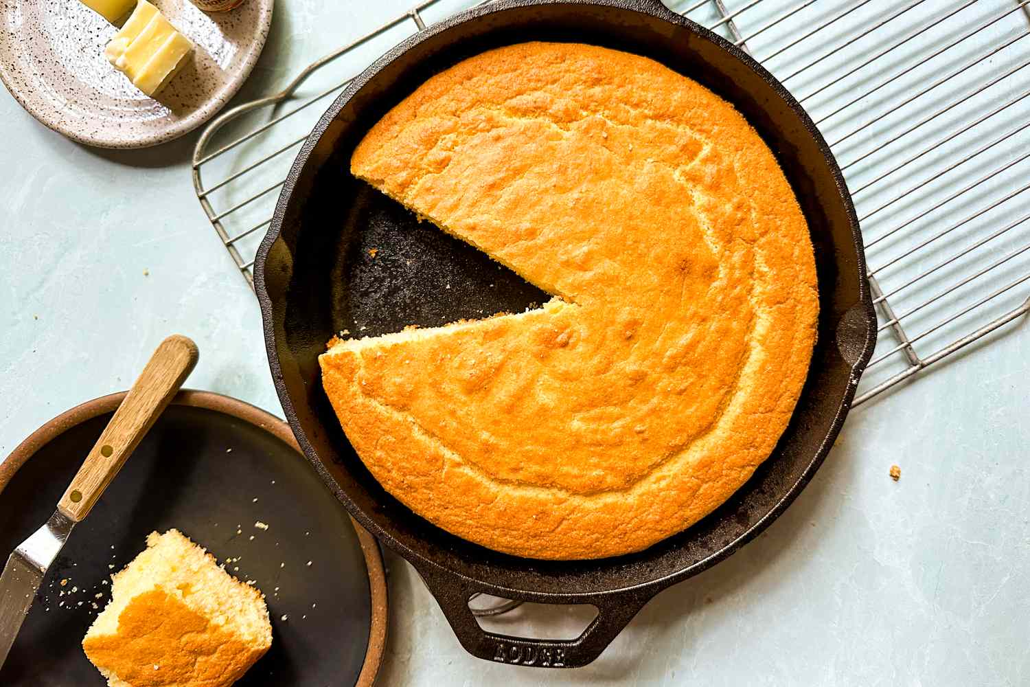 Cornbread in a cast iron skillet cooling on a rack