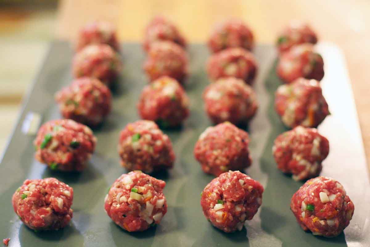 Raw greek meatballs pepared on a cooking sheet 