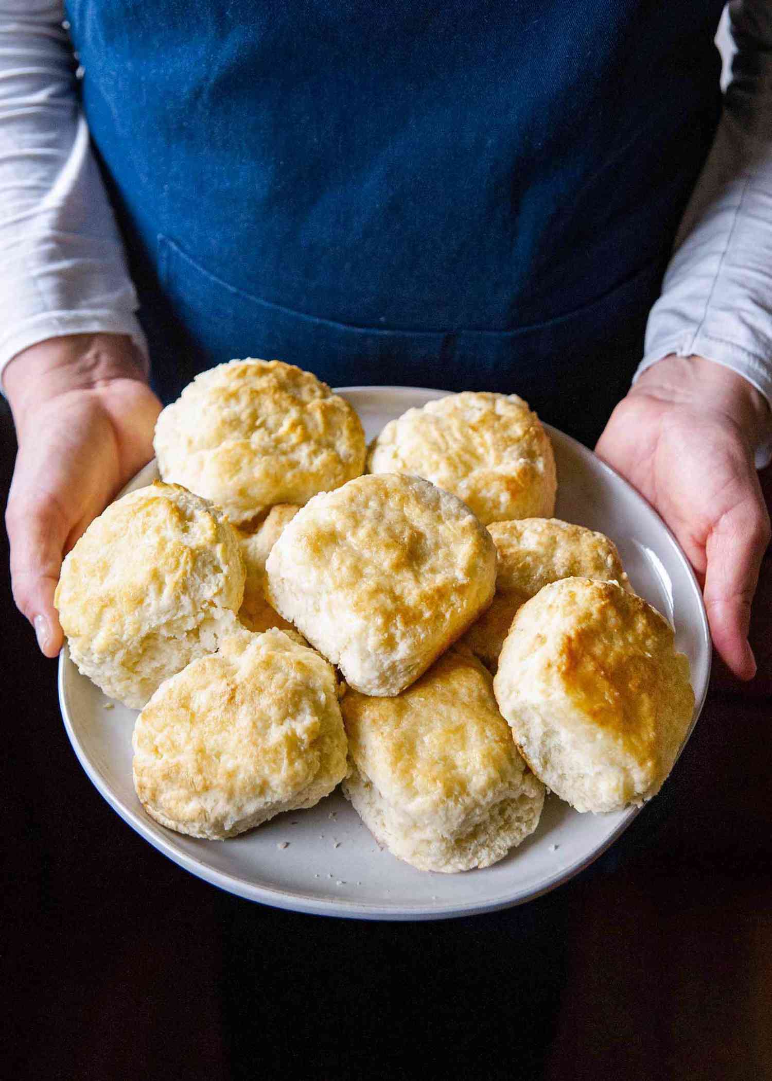 How to make homemade biscuits- hands holding a plate of biscuits