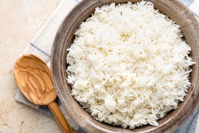 Microwave Rice in a Bowl on a Kitchen Towel with a Wooden Spoon 