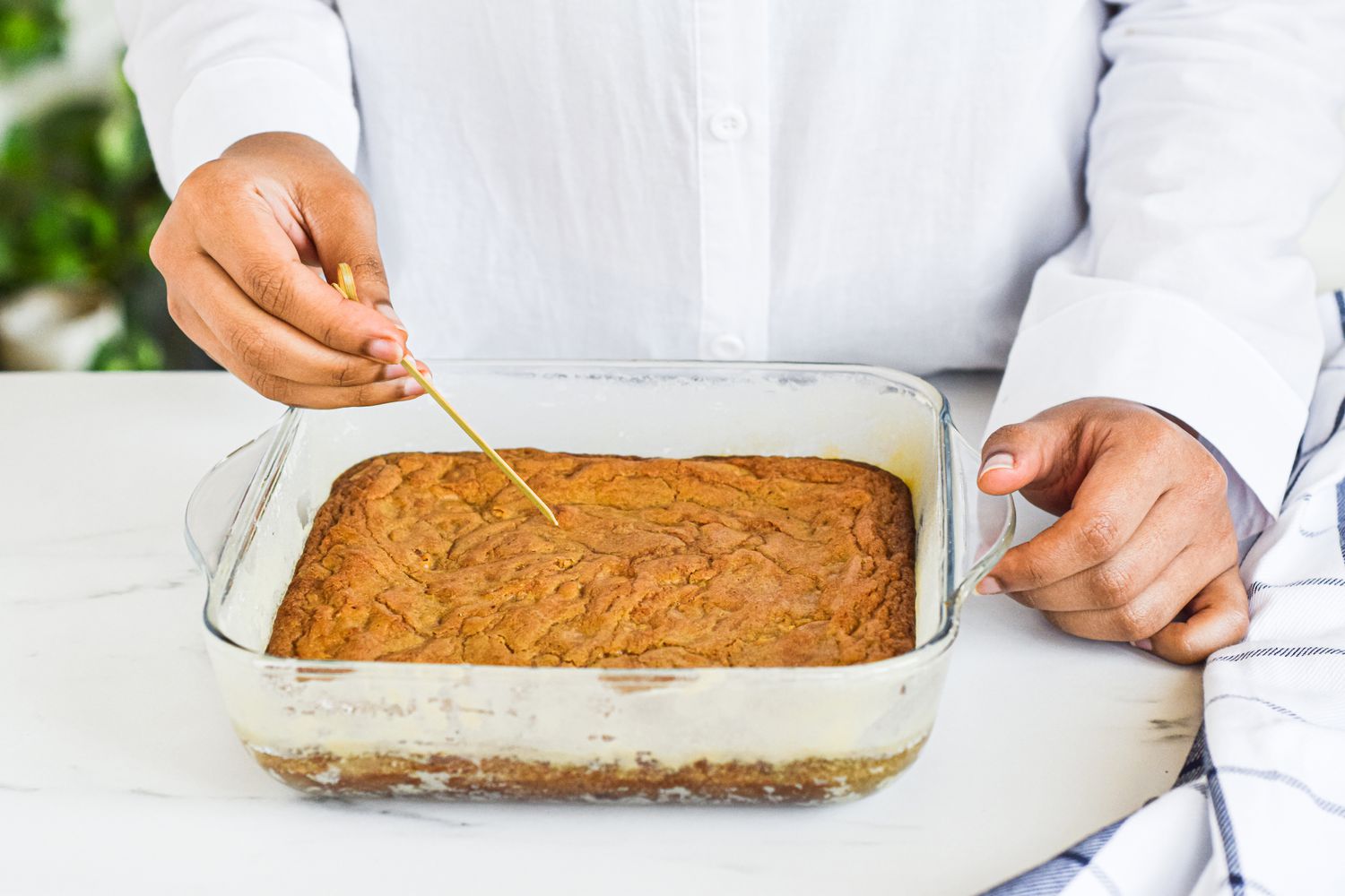 Testing blondies with a toothpick to see if they are done.