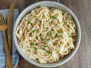 Easy Alfredo Sauce tossed with pasta in serving bowl